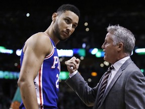 FILE - In this Wednesday, May 9, 2018 file photo,Philadelphia 76ers coach Brett Brown, right, talks with guard Ben Simmons before Game 5 of the team's NBA basketball playoff series against the Boston Celtics in Boston. Philadelphia 76ers coach Brett Brown is expecting more out of guards Ben Simmons and Markelle Fultz this season. The guards failed to hit a 3-pointer last season. Brown says the duo will have to be better from long range this season.