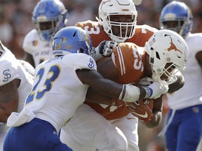 FILE - In this Sept. 9, 2017, file photo, Texas running back Chris Warren III (25) scores a touchdown past San Jose State safety Trevon Bierria (23) with the help of teammate Patrick Hudson (73) during the second half of an NCAA college football game  in Austin, Texas. Hudson was taken to a hospital and treated in intensive care this week because of a heat-related illness at practice, coach Tom Herman said Thursday, Sept. 6, 2018.