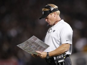 FILE - In this Sept. 10, 2018, file photo, Oakland Raiders coach Jon Gruden looks at at charts during the second half of the team's NFL football game against the Los Angeles Rams in Oakland, Calif. The winless Raiders play the Miami Dolphins, who have won twice, this week.