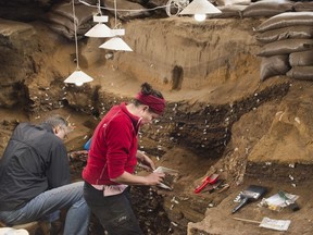 This undated photo provided by Magnus M. Haaland in September 2018 shows researchers in the interior of the Blombos Cave east of Cape Town, South Africa.
