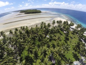 FILE - This Nov. 6, 2015, file photo, shows a large section of land between the trees washed away due to continuing rising sea leaves on Majuro Atoll, Marshall Islands. Small island nations are using the weeklong gathering of world leaders at this year's U.N. General Assembly to highlight the one issue that threatens all of their existence: global warming. On the map, their homes are tiny specks in a vast sea of blue, rarely in the headlines and far removed from the centers of power. But for a few days each year, the leaders of small island nations share the same podium as presidents and prime ministers from the world's most powerful nations, and their message is clear: global warming is already changing our lives, and it will change yours too.