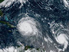 FILE - This Thursday, Sept. 7, 2017 satellite image made available by NOAA shows the eye of Hurricane Irma, left, just north of the island of Hispaniola, with Hurricane Jose, right, in the Atlantic Ocean. Six major hurricanes _ with winds of at least 111 mph (178 kph) _ spun around the Atlantic in 2017, including Harvey, Irma and Maria which hit parts of the United States and the Caribbean. (NOAA via AP)