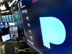 FILE - In this Feb. 22, 2018, file photo, the Pandora logo appears above a trading post on the floor of the New York Stock Exchange. Subscription radio company SiriusXM says it's buying music streaming service Pandora Media Inc. in a stock deal valued at about $3.5 billion that'll allow it to expand its service beyond cars and into homes and other mobile areas.