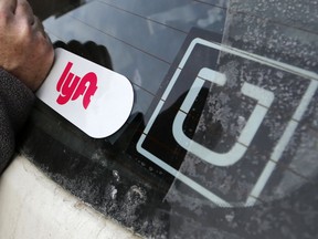 FILE- In this Jan. 31, 2018, file photo, a Lyft logo is installed on a Lyft driver's car next to an Uber sticker in Pittsburgh. The "gig" economy might not be the new frontier for America's workforce after all. From Uber to Lyft to TaskRabbit to YourMechanic, so-called gig work has been widely seen as ideally suited for people who want the flexibility and independence that traditional jobs don't offer. Yet the evidence is growing that over time, they don't deliver the financial returns many expect.