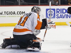Philadelphia Flyers goaltender Anthony Stolarz deflects the puck with his stick on a shot by the New York Islanders in the second period of a preseason NHL hockey game on Tuesday, Sept. 18, 2018, in New York.