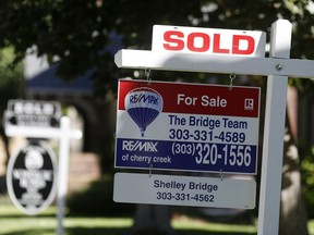 FILE- In this Aug. 30, 2018, file photo sold placards top sale signs outside homes on the market in Denver. On Tuesday, Sept. 25, the Standard & Poor's/Case-Shiller 20-city home price index for July is released.