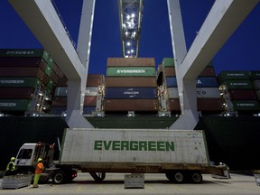 FILE- In this June, 19, 2018, file photo, an Ever Green Line refrigerated container is delivered to a ship to shore crane working the container ship Ever Linking at the Port of Savannah in Savannah, Ga. On Thursday, Sept. 27, the Commerce Department issues the final estimate of how the U.S. economy performed in the April-June quarter.