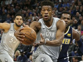 FILE - In this April 11, 2018, file photo, Minnesota Timberwolves' Jimmy Butler drives to the basket ahead of Denver Nuggets' Paul Millsap, right, during the first half of an NBA basketball game in Minneapolis. Butler isn't the first NBA star to ask for a trade, nor will he be the last. But it's far from guaranteed that even if he succeeds in forcing Minnesota into making a move he'll wind up in a place he wants.