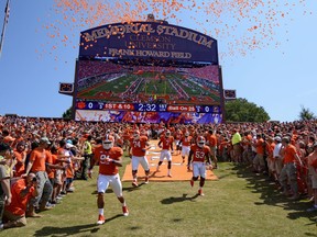 FILE- In this Sept. 7, 2013, file photo, Clemson players run down the hill before the start of an NCAA college football game against South Carolina State at Memorial Stadium in Clemson, S.C. Clemson is moving forward with plans to host its scheduled football game on Saturday while Hurricane Florence wreaks havoc on the Carolinas' coastline with officials bracing for historic flooding and record-setting rainfall that has forced people to evacuate their homes to escape the wrath of the storm.