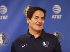 FILE - In tis Feb. 26, 2018, file photo, Dallas Mavericks owner Mark Cuban stands on stage before an NBA basketball press conference in Dallas. Cuban has agreed to contribute $10 million to women's causes and domestic violence awareness as part of the NBA's investigation into workplace conditions with his franchise.