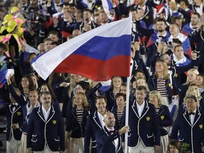 FILE - In this Aug. 5, 2016, file photo, Sergei Tetiukhin carries the flag of Russia during the opening ceremony for the 2016 Summer Olympics in Rio de Janeiro, Brazil. The World Anti-Doping Agency declared Russia's scandal-ridden drug-fighting operation back in business Thursday, Sept. 20, 2018, a decision designed to bring a close to one of sports' most notorious doping scandals but one bitterly disputed by hundreds of athletes and described as "treachery" by the lawyer for the man who exposed the corruption. It also clears a major hurdle for Russia's track team to be declared compliant by that sport's international governing body (IAAF).