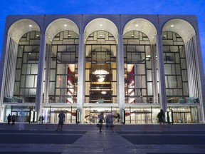 FILE - In this Aug. 1, 2014, file photo, pedestrians make their way in front of the Metropolitan Opera house at New York's Lincoln Center. The Metropolitan Opera will start regular Sunday afternoon performances for the first time in its century-plus history during the 2019-20 season.