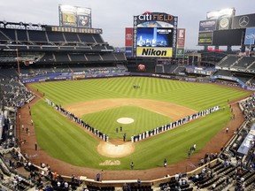 The Miami Marlins and the New York Mets joins members of the New York police and fire departments on the field for pregame ceremonies before a baseball game Tuesday, Sept. 11, 2018, in New York.