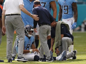 FILE - In this Sept. 9, 2018 file photo Tennessee Titans quarterback Marcus Mariota (8) is attended on the field, during the second half of an NFL football game against the Miami Dolphins in Miami Gardens, Fla. Mariota practiced fully Wednesday, Sept. 12, 2018 after being knocked out of Tennessee's season opener after hurting the elbow on his throwing arm.