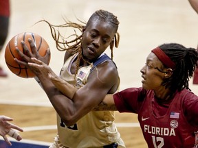 FILE - In this Feb. 4, 2018 file photo Pittsburgh's Yacine Diop, left, maintains control of a rebound as Florida State's Nicole Ekhomu reaches for the ball during the second half of an NCAA college basketball game in Pittsburgh. Several college players are getting quite the education on the court playing against the best players at the FIBA Women's Basketball World Cup. All of them hope to bring their experiences back to school next week when they return to campuses across the U.S. Diop has a great story to tell her new teammates at Louisville. She is headed their as a graduate transfer as playing at Pitt. Diop helped Senegal beat Latvia on Sunday and advance out of pool play for the first time in the country's history. In fact it was the first time in FIBA history that an African team won a preliminary round game.