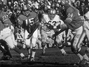 In this undated handout from the Denver Broncos, Marlin Briscoe completes the option to Floyd Little. Fifty years ago, Marlin Briscoe became the first black quarterback to play in the American Football League. He started five games for the Denver Broncos and was runner-up for AP's AFL Rookie of the Year award in 1968. The Pro Football Hall of Fame calls the Omaha, Neb. native the first black quarterback in the modern era of pro football. (Denver Broncos via AP)