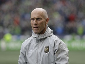 In this March 4, 2018 photo Los Angeles head coach Bob Bradley walks on the pitch before an MLS soccer match against the Seattle Sounders in Seattle.  Probably the most prominent of the "new" coaches this season is MLS vet Bob Bradley, who has the expansion Los Angeles FC in the playoff picture with seven games remaining.