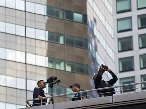 FILE- In this Sept. 17, 2017 file photo, a security team near Trump Tower looks towards high floors of nearby buildings shortly before the arrival of President Donald Trump in New York. Authorities in New York City are facing an epic security and logistical challenge with the upcoming arrival of President Donald Trump and other world leaders for the 73rd session of the United Nations General Assembly.