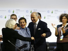 FILE - In this Dec. 12, 2015 file photo,  French foreign minister and President of the COP21 Laurent Fabius, center, hugs France's Laurence Tubiana, special representative for the COP21, left, and United Nations climate chief Christiana Figueres after the final conference of the COP21, the United Nations conference on climate change, in Le Bourget, north of Paris. The international effort to fight climate change is about to get injected with a bit of Hollywood flash, a lot of Wall Street green  and a considerable dose of cheerleading rather than dry treaty negotiations. Business leaders, mayors, governors and activists from around the world gather Wednesday, Sept. 12, 2018, in San Francisco for the Global Climate Action Summit, where participants will trumpet what they've done and announce new efforts to slow a warming world.