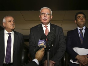 Palestinian minister of foreign affairs Riyad al-Maliki, center, speaks to reporters while Palestinian ambassador to the United Nations Riyad Mansour, left, and Palestinian official Omar Awdallah look on following a meeting in New York, Wednesday, Sept. 26, 2018.