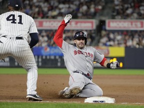 Boston Red Sox's Andrew Benintendi slides into third with a triple during the eighth inning of a baseball game against the New York Yankees Tuesday, Sept. 18, 2018, in New York.