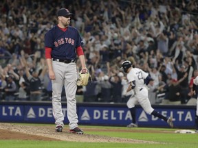 Boston Red Sox relief pitcher Heath Hembree waits as New York Yankees' Giancarlo Stanton runs the bases after hitting a grand slam during the fourth inning of a baseball game Thursday, Sept. 20, 2018, in New York.