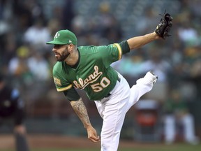 Oakland Athletics pitcher Mike Fiers watches a delivery to the Seattle Mariners during the first inning of a baseball game Friday, Aug. 31, 2018, in Oakland, Calif.