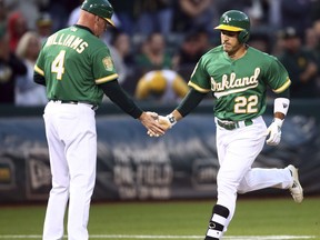 Oakland Athletics' Ramon Laureano, right, is congratulated by third base coach Matt Williams after hitting a home run off Texas Rangers pitcher Yovani Gallardo in the first inning of a baseball game Friday, Sept. 7, 2018, in Oakland, Calif.
