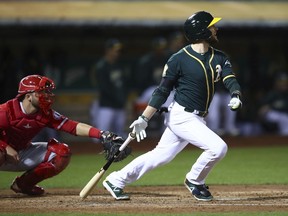 Oakland Athletics' Jed Lowrie drops his bat after hitting a two-run double off Los Angeles Angels' Felix Pena during the fourth inning of a baseball game Wednesday, Sept. 19, 2018, in Oakland, Calif.