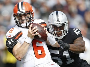 Cleveland Browns quarterback Baker Mayfield (6) tries to escape the grasp of Oakland Raiders defensive end Bruce Irvin (51) during the first half of an NFL football game in Oakland, Calif., Sunday, Sept. 30, 2018.
