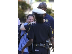 A woman is comforted by authorities stationed outside the University of Cincinnati Medical Center's Emergency room following a shooting in downtown Cincinnati that left at least four dead, including the gunman, and several injured, Thursday, Sept. 6, 2018, in Cincinnati.