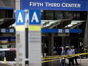 FILE - In this Sept. 6, 2018 file photo, police investigate outside Fifth Third Bank building on Fountain Square after a shooting with multiple fatalities in downtown Cincinnati. The two shooting victims who survived the gunman's attack are both back home. Whitney Austin was discharged from UC Medical Center on Tuesday, Sept. 11.  Brian Sarver was released Monday.