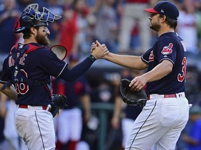 Cleveland Indians relief pitcher Brad Hand, right, is congratulated by catcher Eric Haase after defeating the Detroit Tigers 15-0 in a baseball game, Saturday, Sept.15, 2018, in Cleveland.