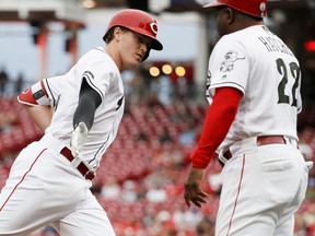 Cincinnati Reds' Brandon Dixon, left, celebrates with third base coach Billy Hatcher (22) after hitting a solo home run off Los Angeles Dodgers starting pitcher Hyun-Jin Ryu in the second inning of a baseball game, Tuesday, Sept. 11, 2018, in Cincinnati.