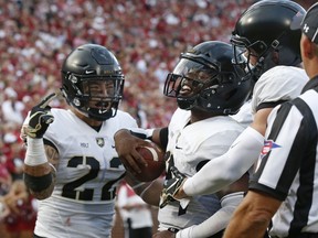 Army quarterback Kelvin Hopkins Jr. (8) celebrates with teammates Calen Holt (22) and Camden Harrison, right, after scoring against Oklahoma in the first half of an NCAA college football game in Norman, Okla., Saturday, Sept. 22, 2018.
