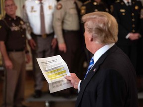 Donald Trump reads from an article praising his administration as responds to an anonymous "senior official" who wrote an op-ed article entitled "I Am Part of the Resistance Inside the Trump Administration" in The New York Times on September 5.