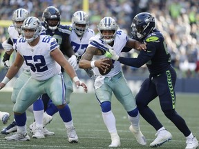 Dallas Cowboys quarterback Dak Prescott (4) is sacked by Seattle Seahawks defensive end Frank Clark, right, during the second half of an NFL football game, Sunday, Sept. 23, 2018, in Seattle.