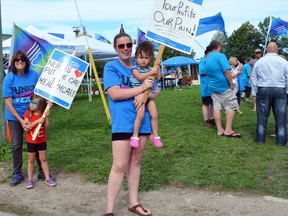 Alysha McDonald of Elora, holding two-year-old daughter Everly, brought her two children (Kinley, 5, is at left) to an OPSEU event Wednesday to show support for McDonald's aunt Myrna Stewart, far left, who is one of the OPSEU Local 276 workers who are on strike at the Owen Sound Family Health Team medical clinic.
