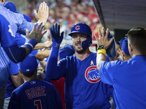 Chicago Cubs' Kris Bryant, center, is congratulated after scoring on a triple by Kyle Schwarber during the third inning of a baseball game against the Philadelphia Phillies, Saturday, Sept. 1, 2018, in Philadelphia.