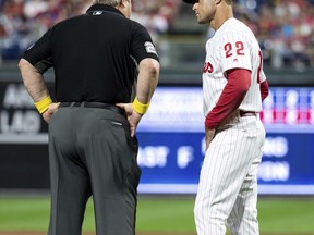 Umpire Joe West, left, talks with Philadelphia Phillies manager Gabe Kapler, right, about the situation with relief pitcher Austin Davis during the eighth inning of a baseball game against the Chicago Cubs, Saturday, Sept. 1, 2018, in Philadelphia. West confiscated a card from Davis. Davis and Phillies manager Gabe Kapler said he was using the card merely for information on the Cubs hitters. But West said it was illegal under Rule 6.02(c)(7), which states that the pitcher shall not have on his person, or in his possession, any foreign substance. The Cubs won 7-1.