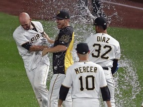 Pittsburgh Pirates' Jacob Stallings, left, is held by Chad Kuhl (39) as Elias Diaz (32) showers him while celebrating after hitting a walkoff single off Kansas City Royals relief pitcher Ben Lively in the bottom of the ninth of a baseball game in Pittsburgh, Monday, Sept. 17, 2018.