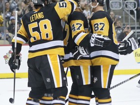 Pittsburgh Penguins' Adam Johnson (47) celebrates with Sidney Crosby (87) and Kris Letang (58) after scoring against the Columbus Blue Jackets during the second period of an NHL preseason hockey game, Saturday, Sept. 22, 2018, in Pittsburgh.