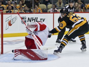 Pittsburgh Penguins' Teddy Blueger, right, scores against Detroit Red Wings goalie Harri Sateri, left, during the second period of an NHL preseason hockey game, Sunday, Sept. 23, 2018, in Pittsburgh.