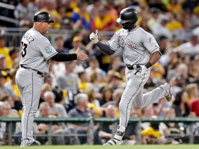 Miami Marlins' Lewis Brinson, right, is greeted by third base coach Fredi Gonzalez after hitting a three-run home run in the sixth inning of a baseball game against the Pittsburgh Pirates, Friday, Sept. 7, 2018, in Pittsburgh.