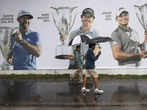 Volunteers shield from the rain with umbrellas during a rainy day at the Aronimink Golf Club in Newtown Square, Pa., Sunday, Sept. 9, 2018. The BMW Championship final round is delayed due to weather.