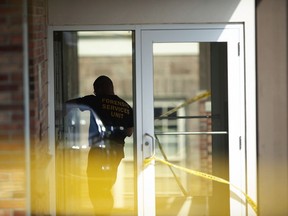 An officer investigates a shooting that occurred in the Masontown borough municipal center on Wednesday, September 19, 2018, in Masontown, Pa. A gunman opened fire outside a crowded courtroom Wednesday afternoon, shooting at police and others before an officer fired multiple shots at him, killing him.
