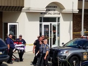 Law enforcement and emergency personnel gather outside the office of District Judge Daniel Shimshock's office in Masontown, Pa., Wednesday Sept. 19, 2018. At least four people were shot at the office. Details were not immediately available on the conditions of the victims.