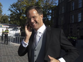 Dutch Prime Minister Mark Rutte flashes a thumbs up as he talks on in his phone in The Hague, Netherlands, Tuesday, Sept. 18, 2018, prior to a ceremony marking the opening of the parliamentary year with a speech by King Willem-Alexander outlining the government's budget plans for the year ahead.