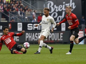 Rennes' Benjamin Andre, left, and Rennes' Benjamin Bourigeaud, right, defend on PSG's Neymar during their French League One soccer match between Rennes and Paris-Saint-Germain at Roazhon Park stadium in Rennes, western France, Sunday, Sept. 23, 2018.