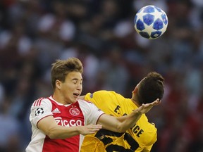 Ajax's Carel Eiting, left, and AEK's Ezequiel Ponce jump to head the ball during a Group E Champions League soccer match between Ajax and AEK at the Johan Cruyff ArenA in Amsterdam, Netherlands, Wednesday, Sept. 19, 2018.